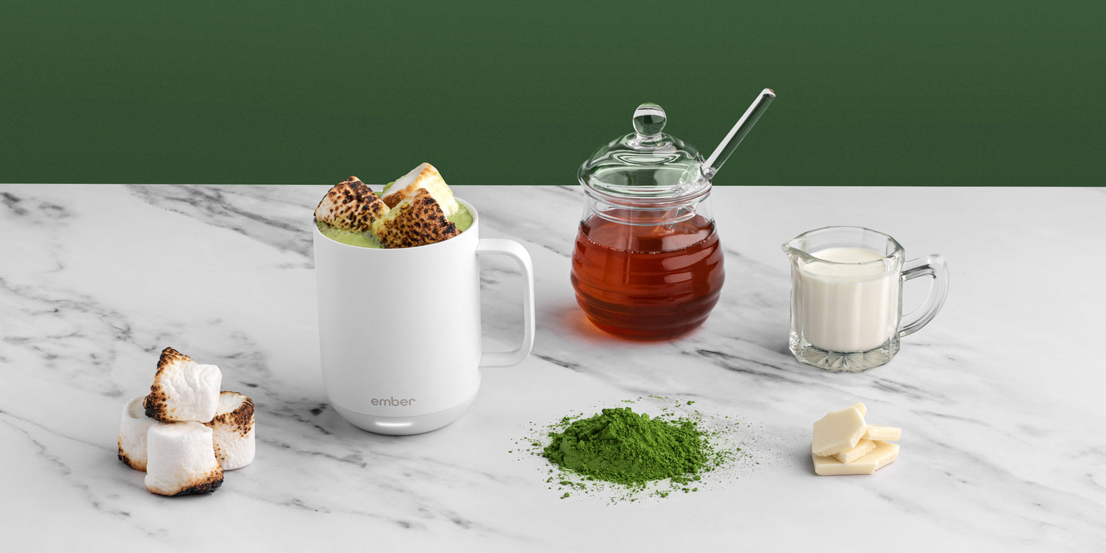 Matcha Hot Chocolate in a white Ember Mug2 and surrounded by toasted marshmallows, honey, and cream.
